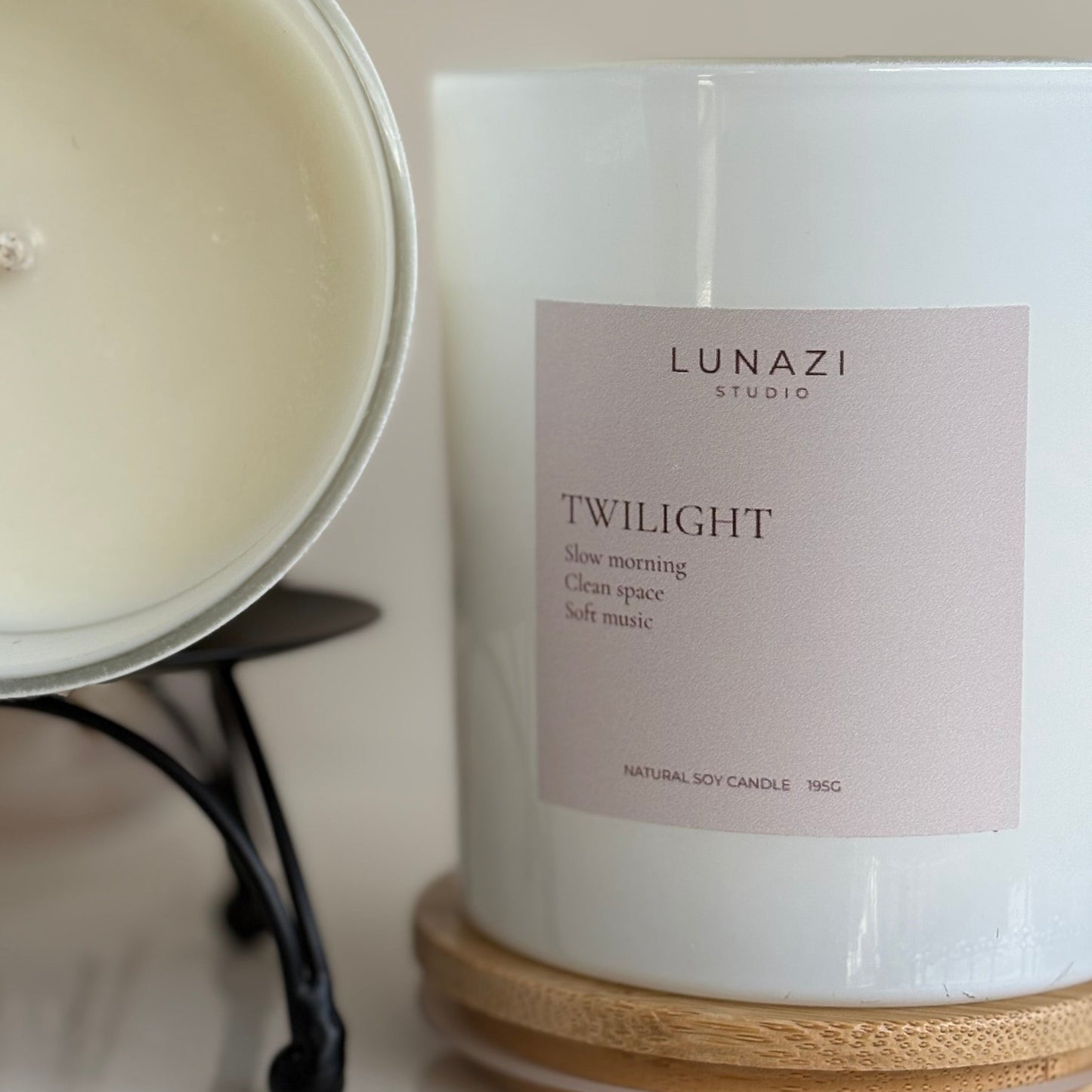 A close up image of a luxury scented soy candle in a glossy white Jar. 